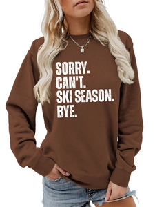 Detail of SORRY CAN'T SKI SEASON BYE slogan print on brown crewneck sweatshirt
