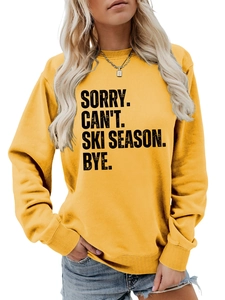 Detail of soft yellow crewneck sweatshirt featuring bold SORRY CAN'T SKI SEASON text print