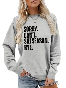 Detail of ribbed cuffs and hem on a gray long-sleeve sweatshirt with ski season slogan