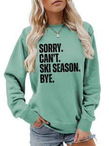 Detail of mint green sweatshirt featuring SORRY CAN'T SKI SEASON slogan and ribbed neck