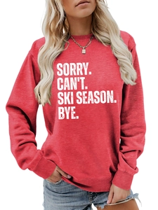 Detailed close-up of red crewneck sweatshirt with vintage SORRY CAN'T SKI SEASON print