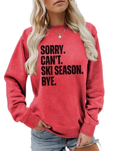Detail of red crewneck sweatshirt featuring SORRY CAN'T SKI SEASON slogan text
