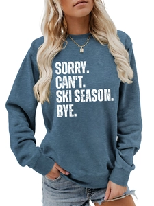 Detail of blue crewneck sweatshirt featuring white SORRY CAN'T SKI SEASON text print