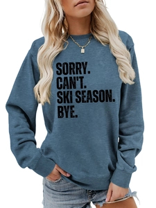 Detail of blue-grey sweatshirt featuring Sorry Can't Ski Season Bye printed text