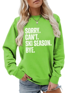 Close-up of SORRY CAN'T SKI SEASON lettering on a green crewneck sweatshirt