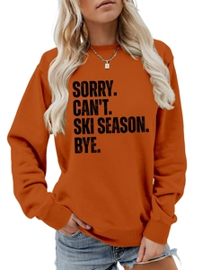Detail of orange round neck sweatshirt with black SORRY CAN'T SKI SEASON slogan print
