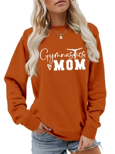 Detailed view of the ribbed cuffs and white Gymnastics MOM print on a burnt orange sweatshirt
