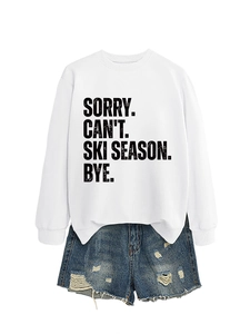 Detail of white crewneck sweatshirt with Ski Season print and distressed denim shorts