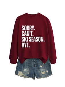 Detail of burgundy long sleeve sweatshirt with white slogan and distressed denim shorts