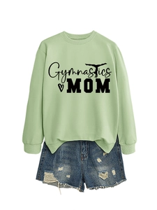 Close-up of Gymnastics Mom print on light green sweatshirt with denim shorts details