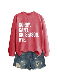 Detail of red crewneck sweatshirt with Sorry Can't Ski Season text and denim shorts