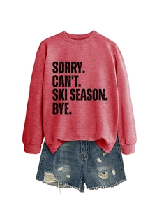 Close-up of SORRY CAN'T SKI SEASON text on a comfortable red long sleeve sweatshirt