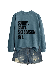 Flat lay of navy crewneck sweatshirt with ski season slogan and ripped denim shorts set
