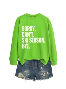 Detail of bright green sweatshirt with Sorry Can't Ski Season print and ripped denim shorts