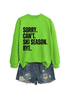 Detail of Sorry Can't Ski Season letter print on neon green sweatshirt with denim shorts