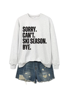 Detail of white cotton sweatshirt with SORRY CAN'T SKI SEASON slogan and denim shorts