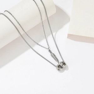 Minimalist silver-tone double layer necklace featuring feather and O-ring pendants