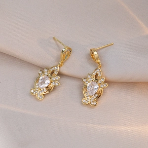 Retro gold drop earrings with pear-cut crystals and floral texture in vintage palace style