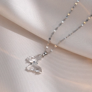 Titanium steel butterfly pendant necklace with zircon stones on white satin background