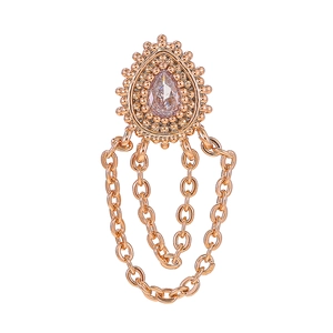 Detalle macro de pendientes de borla en oro rosa con circón en gota y textura de pedrería