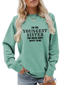 Close-up of mint green sweatshirt with bold black text print for youngest sisters