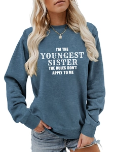 Close-up of I'M THE YOUNGEST SISTER white art font print on a blue-grey sweatshirt
