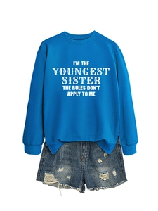 Detail of blue crewneck sweatshirt with 'Youngest Sister' print and ripped denim shorts