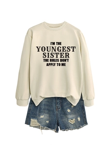Detail of cream sweatshirt with 'I'M THE YOUNGEST SISTER' text and blue denim shorts