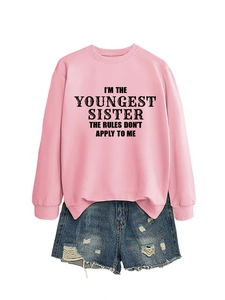 Flat lay of pink sister slogan sweatshirt paired with distressed blue denim shorts