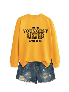 Flat lay of ginger yellow sweatshirt with Youngest Sister text and ripped denim shorts