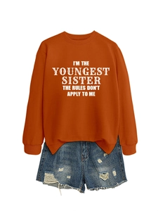 Detail of orange sweatshirt with I'M THE YOUNGEST SISTER slogan and denim shorts