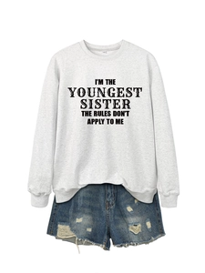Detail of grey sweatshirt with 'I'M THE YOUNGEST SISTER' text and denim shorts