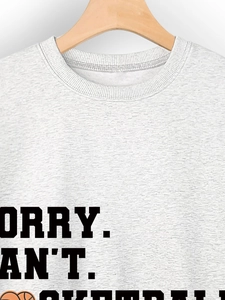 Close-up of SORRY CAN'T BASKETBALL text on heather grey crewneck sweatshirt fabric