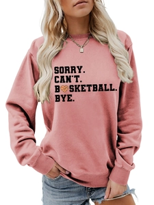 Close-up of SORRY CAN'T BASKETBALL BYE text with heart-shaped basketball on pink hoodie
