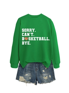 Detail of green knit sweatshirt with white Basketball text and distressed denim shorts