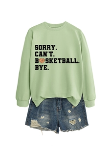 Detail of green sweatshirt with basketball slogan print and ripped denim shorts