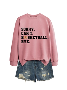 Flat lay of pink crewneck sweatshirt with basketball slogan and distressed denim shorts