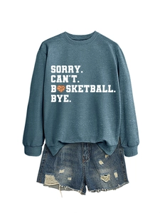 Detail of blue sweatshirt with 'Sorry Can't Basketball Bye' slogan and orange heart ball