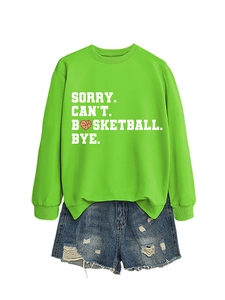 Close-up of green sweatshirt with basketball heart print and ripped denim shorts