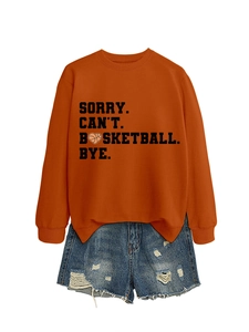 Flat lay of an orange sweatshirt with basketball slogan and blue denim shorts set