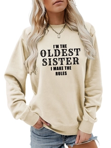 Detail of beige crewneck sweatshirt featuring I'M THE OLDEST SISTER vintage black text