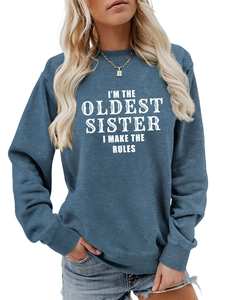 Detail of greyish blue sweatshirt featuring I'M THE OLDEST SISTER white printed text