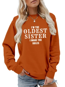Detail view of caramel crewneck sweatshirt with 'I'M THE OLDEST SISTER' white text print