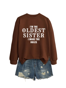 Detail of a brown sweatshirt with white text and distressed blue denim shorts