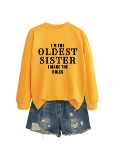 Close-up of yellow graphic sweatshirt and distressed denim shorts with frayed edges