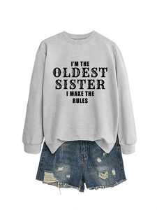 Detail of I'M THE OLDEST SISTER slogan print on a grey long sleeve sweatshirt and denim shorts