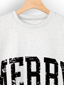 Close-up of the ribbed crewneck and vintage MERRY lettering on this grey sweatshirt