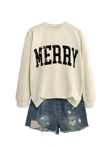 Detail of MERRY slogan on off-white sweatshirt paired with distressed denim shorts