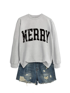 Flat lay of a grey sweatshirt with black MERRY lettering and ripped denim shorts