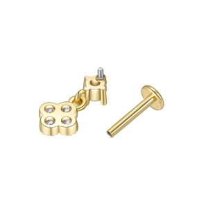 Detailed macro view of a gold four-petal flower labret stud with inlaid zircon crystals